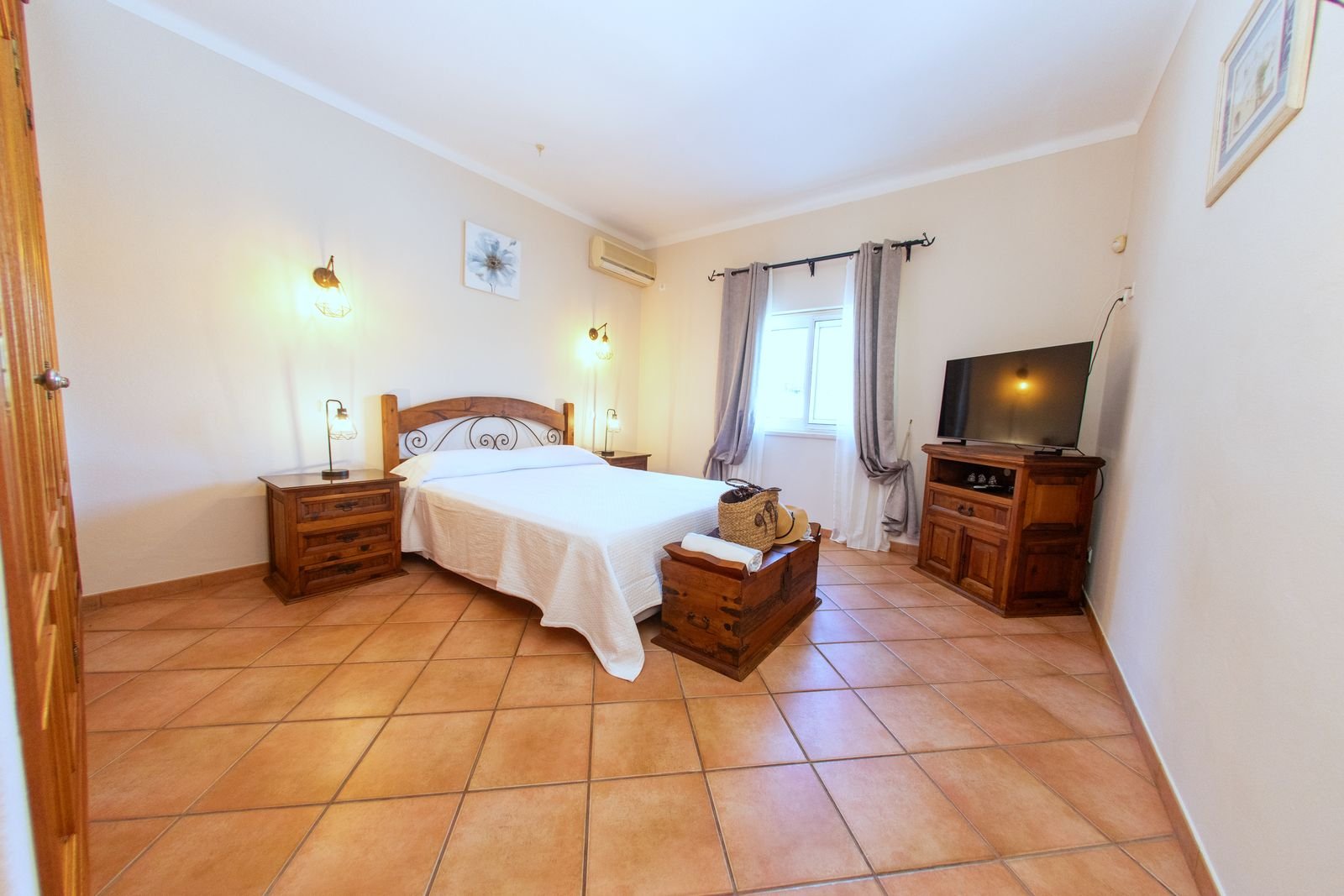Ground floor double bedroom with a wooden bed and television