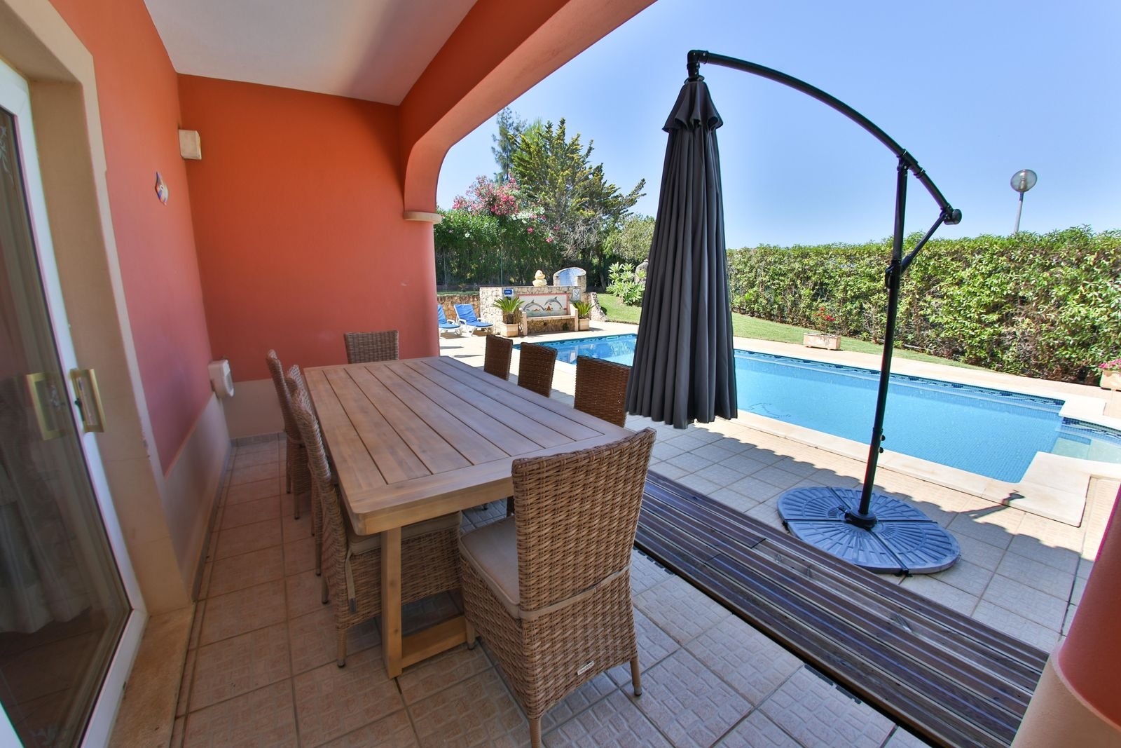 Covered terrace with a long dining table overlooking the private pool at Casa Eunice, Carvoeiro, Algarve